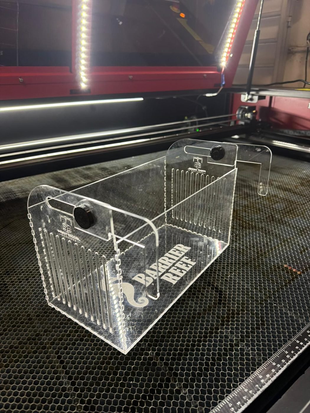 Clear acrylic box engraved with Barrier Reef logo on laser cutter